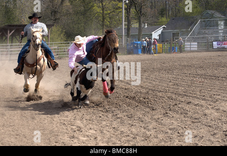 Garçon rivalise wrestling calf n New York High school rodeo. Les adolescents actifs dans un défi physique sports USA Banque D'Images