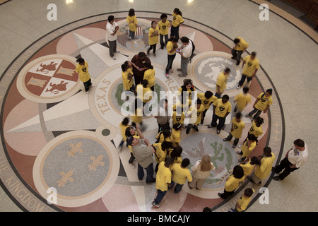 Les enfants de l'école à la recherche au niveau des joints sur le plancher du bâtiment du Capitole de l'état du Texas à Austin rotonde Banque D'Images