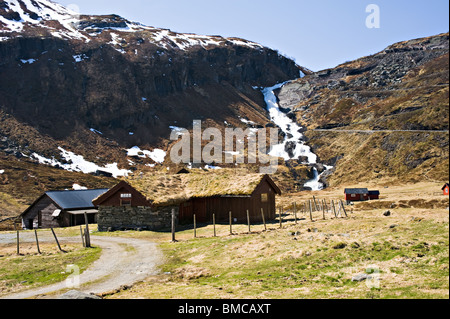 Maison de cabines dans la vallée de l'Holo à distance avec cascade au débit rapide, descendant en pente Sogn Norvège Banque D'Images