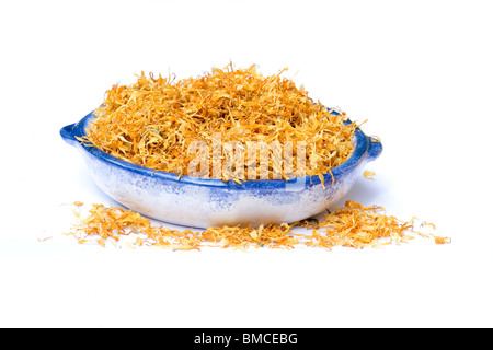 Close-up of bowl avec calendula fleurs séchées sur fond blanc Banque D'Images