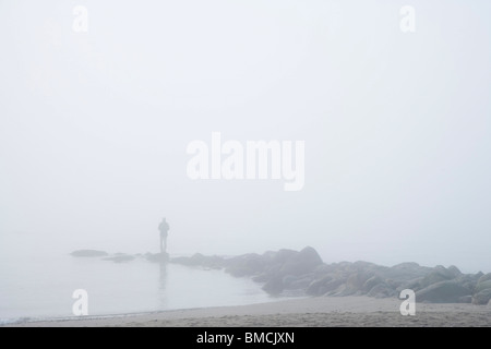 L'homme sur des rochers dans le brouillard Banque D'Images