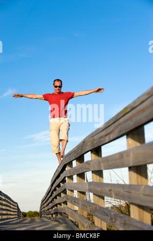 L'équilibrage de l'homme sur la balustrade de bois, Honeymoon Island, Floride, USA Banque D'Images