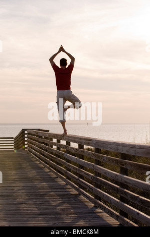 L'équilibrage de l'homme sur la balustrade de bois, Honeymoon Island, Floride, USA Banque D'Images