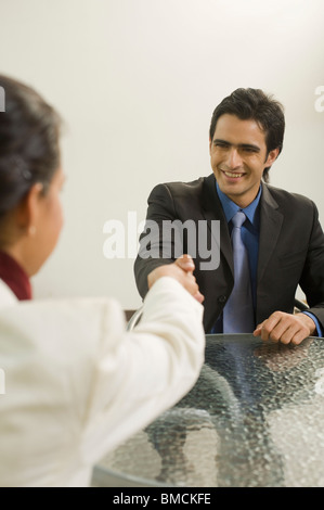 Businessman shaking hands with a woman Banque D'Images