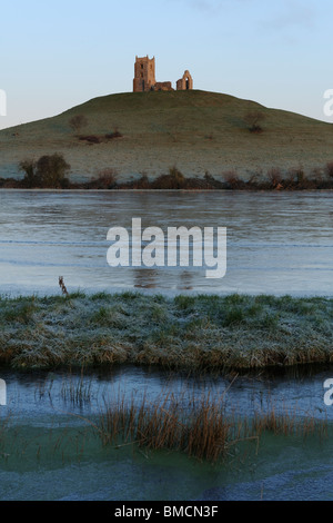 Burrow Mump dans Somerset reflète dans l'eau des crues congelées à l'aube d'un matin d'hiver. Banque D'Images