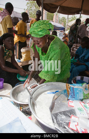 Une femme vend des boules de tapioca dans le lait près du Grand marché de Bamako, Mali. Banque D'Images