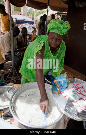 Une femme vend des boules de tapioca dans le lait près du Grand marché de Bamako, Mali. Banque D'Images