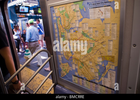 Les passagers passent un plan de métro lorsqu'ils monteront à bord d'un train Q à Brooklyn à New York Banque D'Images