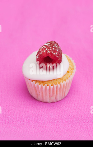 Mini cupcake framboise fruits colorés sur fond rose Banque D'Images