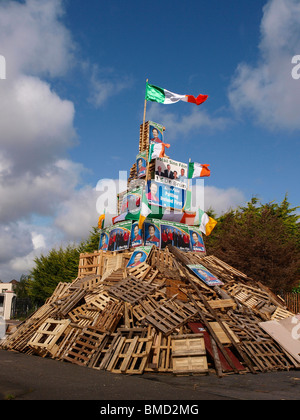 11e nuit feu loyaliste décoré avec le drapeau irlandais et des affiches électorales d'hommes politiques nationalistes. Banque D'Images