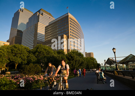 Cycle de deux hommes sur un chemin le long de la rivière Hudson dans la région de Battery Park City, New York. Banque D'Images