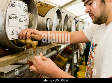 Un travailleur bar versant une pinte de vraie bière à la fête de la bière du cerceau dans l'Essex. Photo par Gordon 1928 Banque D'Images