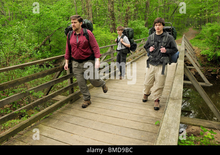 Trois randonneurs traversant une passerelle le long du chemin des Patriotes en procès Jockey, environs de Morristown, New Jersey, USA Banque D'Images