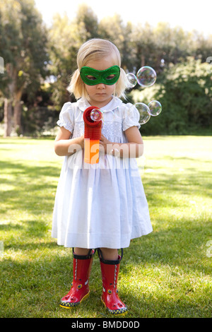 Jeune fille au masque avec canon à bulles Banque D'Images