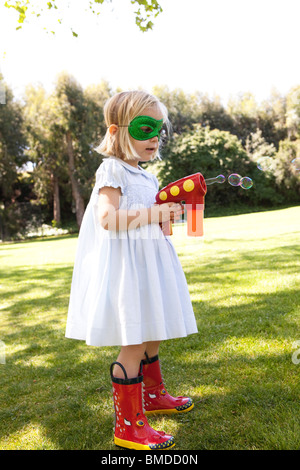 Jeune fille au masque avec canon à bulles Banque D'Images