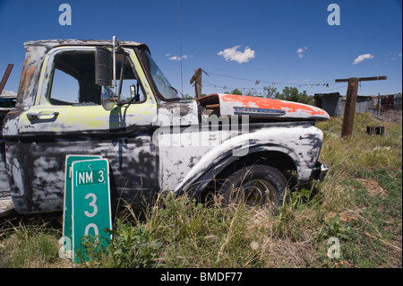 Une vue fréquente au Nouveau Mexique - un multi-couleurs, abandonnés, non-fonctionnement de camionnette stationnée dans la lutte contre les mauvaises herbes-patch - Encino, NM Banque D'Images