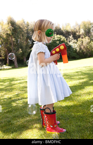 Jeune fille au masque avec canon à bulles Banque D'Images