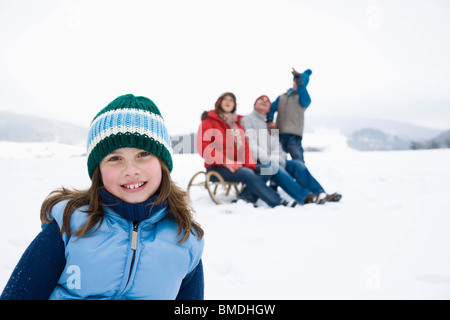 Jeune fille à l'extérieur en hiver avec la famille Banque D'Images