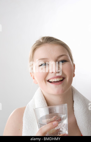 Femme en sueur avec verre de l'eau Banque D'Images