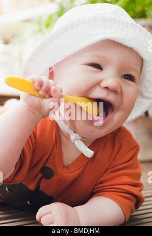 Bébé à mâcher sur cuillère en plastique Banque D'Images