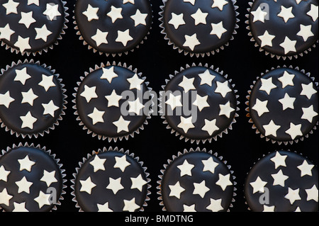 Mini cupcakes décorés de glaçage au chocolat noir et blanc stars Banque D'Images