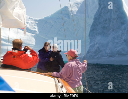 Les touristes ayant leur photo prise en face d'un iceberg sur une excursion en bateau dans la baie de Trinity, à Terre-Neuve, Canada Banque D'Images