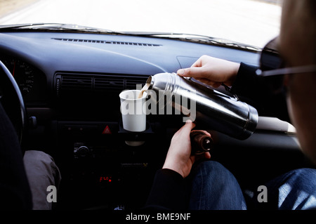 L'homme ayant une tasse de café dans la voiture, au Danemark. Banque D'Images