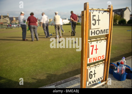 Vue arrière d'un groupe d'hommes d'âge moyen de jouer à un jeu de boules vert pelouse un soir d'été, Aberystwyth Wales UK Banque D'Images