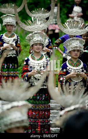 Les jeunes femmes Miao en costume traditionnel avec les touristes de vœux dans la région de Langde vin, Village de Leishan, Guizhou, Chine Banque D'Images