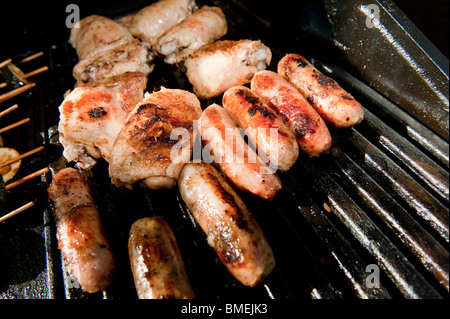 Les saucisses et le poulet d'être cuits ensemble sur un barbecue. Banque D'Images