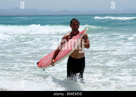 Homme surf sur plage de Wategos, Byron Bay, Australie. Banque D'Images