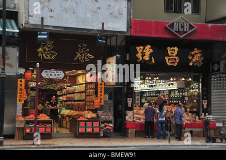 Après-midi tourné de deux fruits de mer séchés illuminée et la médecine chinoise boutiques, Des Voeux Road West, Sai Ying Pun, Hong Kong, Chine Banque D'Images