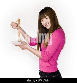 Chinese girl eating spaghetti Banque D'Images