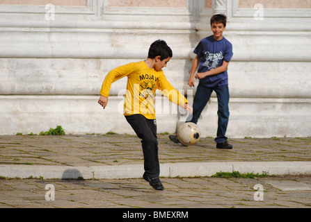 Les enfants jouent au football dans un piazza à Venise, Italie Banque D'Images