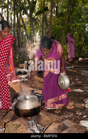 L'Inde, le Kerala, femme Kodikuthu Kanjiramattom festival, en remuant pongal dans chaudron sur feu de bois ouvert Banque D'Images