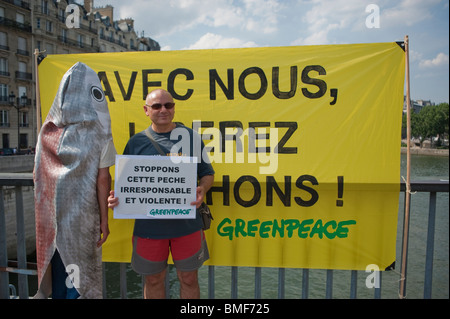 Man Holding Sign avec des activistes de Greenpeace qui manifestent contre le Thon Rouge Pêche, journée de manifestation, Paris, France Banque D'Images