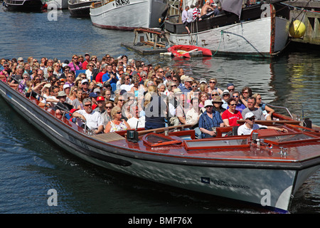 Un tour en bateau de croisière plein de touristes d'été s'en va sur Nyhavn une croisière dans le port de Copenhague. Banque D'Images