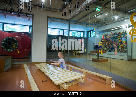Une fille à jouer dans un xylophone géant au sous-sol de l'enfant dans le Deutsches Museum, Museumsinsel, Munich, Allemagne Banque D'Images