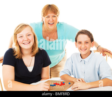 Mère et deux enfants ont plaisir à jouer des jeux de société. Isolé sur blanc.