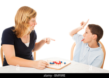 Au volant de son petit frère soeur adolescente crazy pendant qu'ils jouent un jeu. Isolé sur blanc.