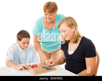 La mère et deux enfants jouer à des jeux de société. Isolé sur blanc.