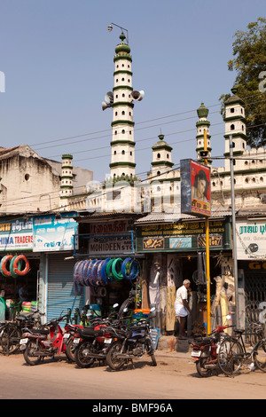 L'Inde, le Tamil Nadu, Madurai, petite mosquée avec phare-comme minarets derrière boutiques Banque D'Images