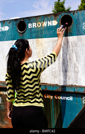 Banque de recyclage pour le verre utilisé par jeune femme Banque D'Images