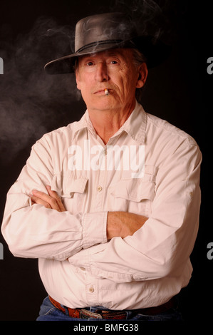 Senior man wearing a cowboy hat fumeurs Banque D'Images