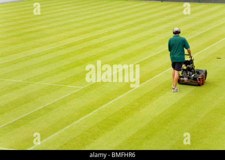 Groundsman à tous les Tennis Club de Wimbledon en Angleterre, SW19, tondre le gazon sur le Court central. UK. Banque D'Images