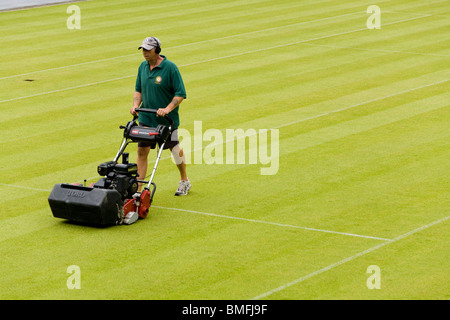 Groundsman à tous les Tennis Club de Wimbledon en Angleterre, SW19, tondre le gazon Tennis Center Court. UK. Banque D'Images