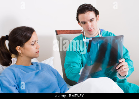 La visite de son médecin patient in hospital ward et montrant son x-ray suite Banque D'Images