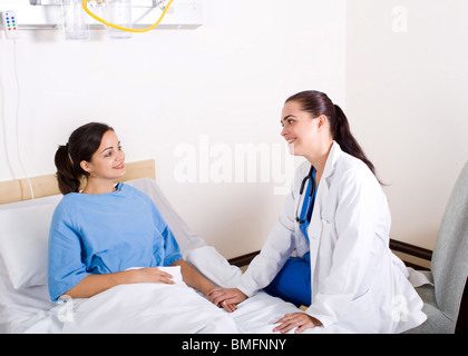 Jeune femme médecin lui rendre visite à son patient en service de médecine Banque D'Images