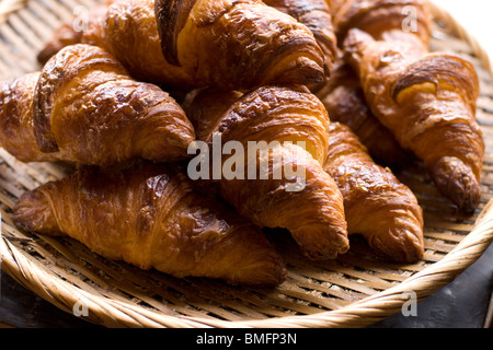 Les croissants pour la vente sur un panier de bambou dans une boulangerie française Banque D'Images