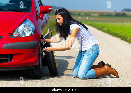 Jeune femme avec un pneu de voiture à ventilation Banque D'Images